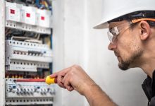 man electrical technician working switchboard with fuses installation connection electrical equipment close up