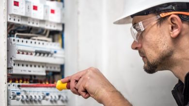 man electrical technician working switchboard with fuses installation connection electrical equipment close up